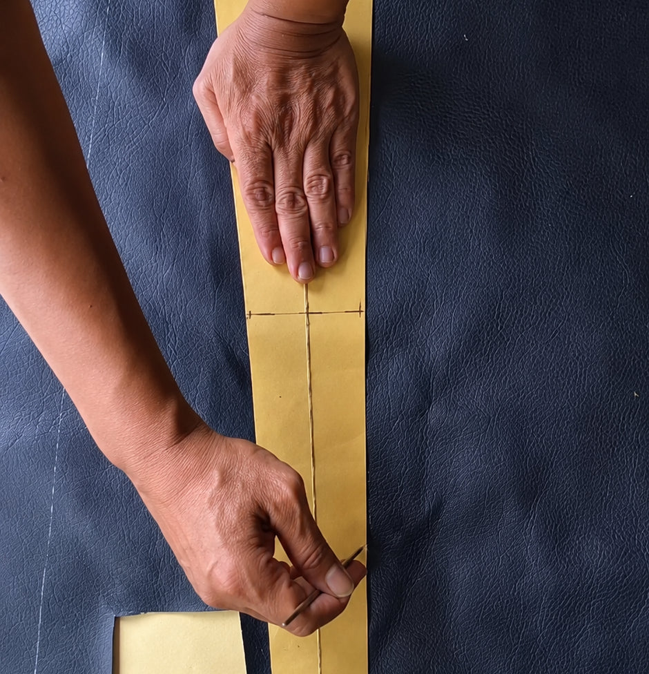 Person tracing Bag shape onto leather 