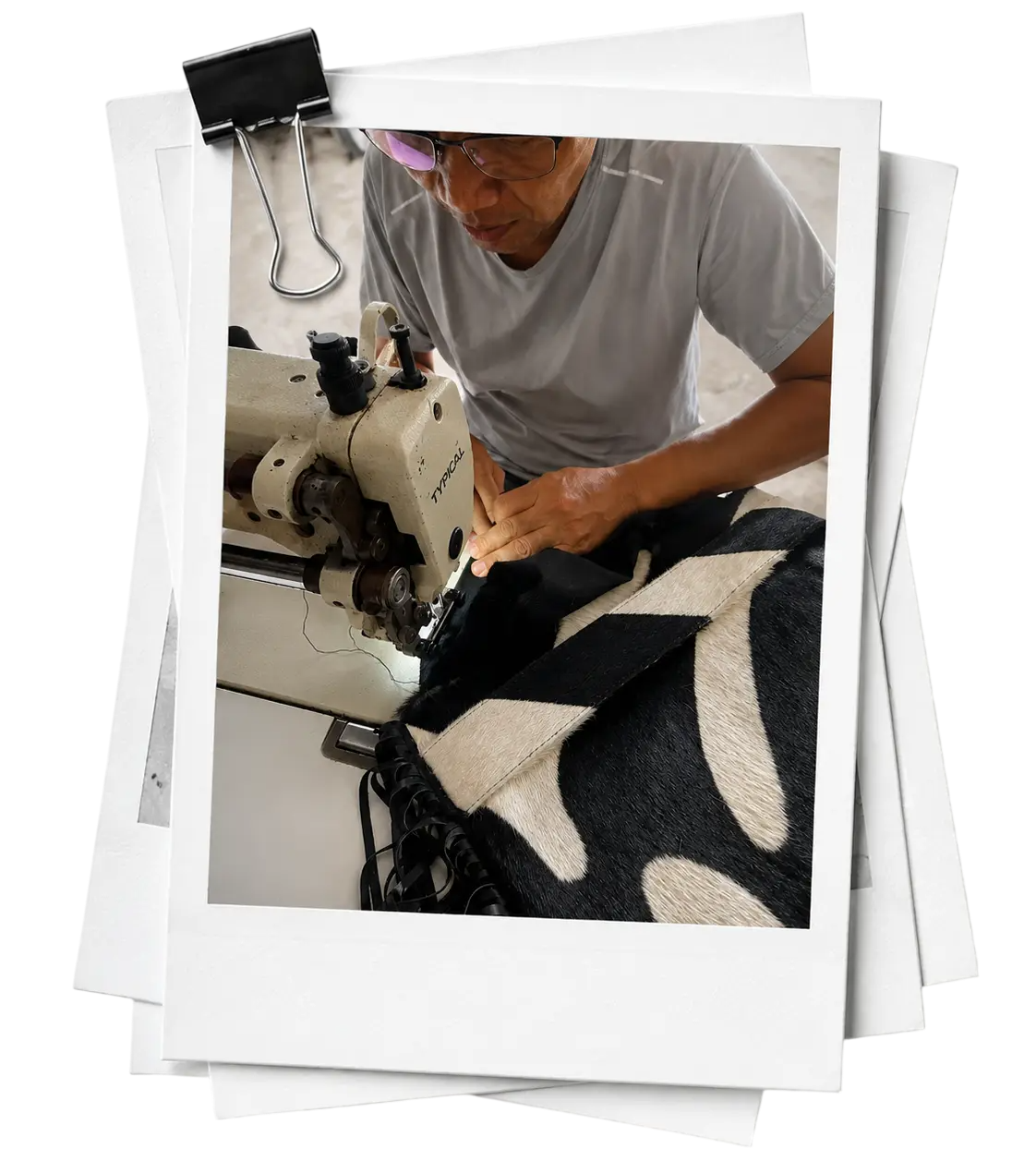 Person working on a sewing machine with fabric, framed as if it were a photo.